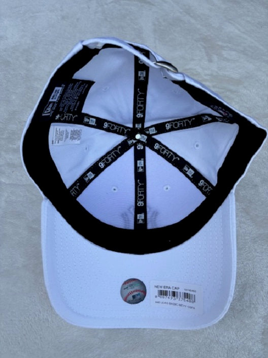 A white baseball cap shown from the inside, featuring a black curved brim, black interior straps with white 'FORTY' text, and a small baseball patch on the front.